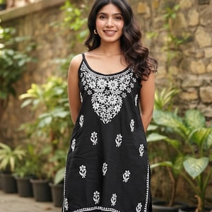 Black cotton chikankari sleeveless short kurti with noodle straps, white embroidered neckline and scattered motifs.