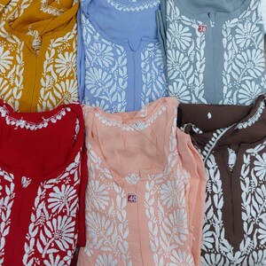 Puede incluir: Una colecci&oacute;n de seis t&uacute;nicas de manga larga en amarillo mostaza, azul claro, gris, rojo, melocot&oacute;n y marr&oacute;n. Cada t&uacute;nica presenta un patr&oacute;n de bordado floral blanco, un escote con abertura y una etiqueta de talla 38 o 40 en algunas.
