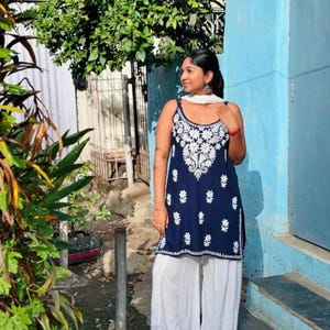 Navy blue cotton chikankari short top with white Lucknowi embroidery; sleeveless noodle-strap kurti paired with white cotton pants.