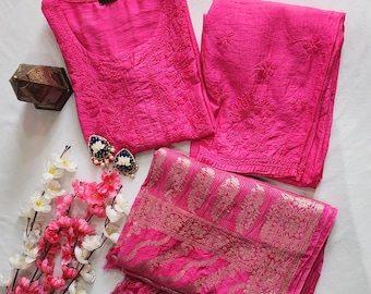 May include: A bright pink three-piece outfit consisting of a long-sleeved tunic with intricate tonal embroidery, matching trousers with floral embroidery, and a pink dupatta featuring a metallic gold woven border and decorative tassels.