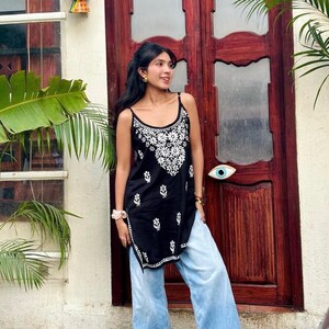 Black cotton chikankari short kurti top with Lucknowi white embroidery; sleeveless noodle-strapped embroidered tunic.