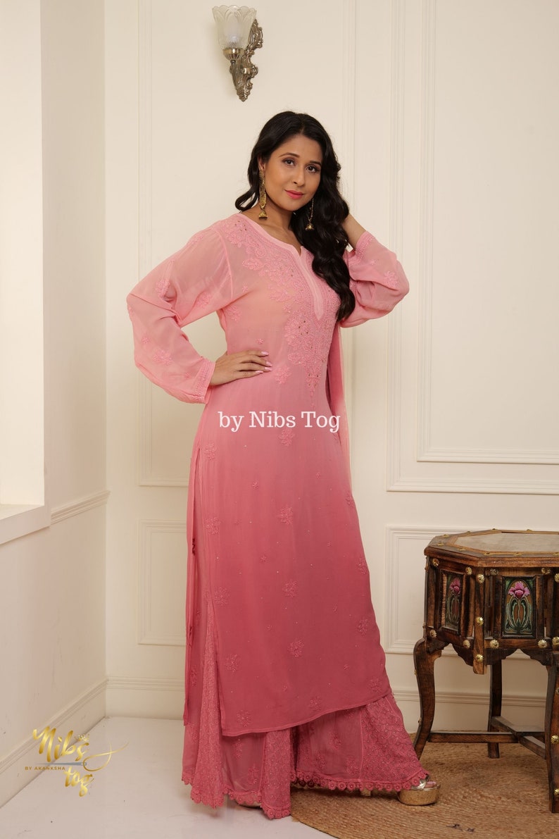 May include: A pink ombre chikankari kurta with long sleeves and a matching palazzo pant. The kurta has intricate embroidery and a delicate lace trim. The text "by Nibs Tog" is visible on the image.