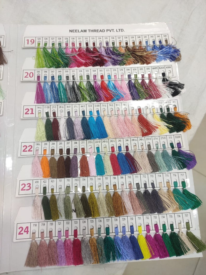 May include: A color chart of thread spools with a variety of colors, including red, blue, green, yellow, orange, and purple. The chart is labeled "NEELAM THREAD PVT. LTD." and has numbers 19 through 24 along the left side.