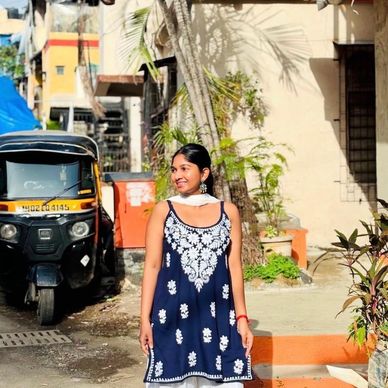 Handmade navy blue cotton chikankari short kurta top with white embroidery, sleeveless noodle-strap design and scattered motifs.