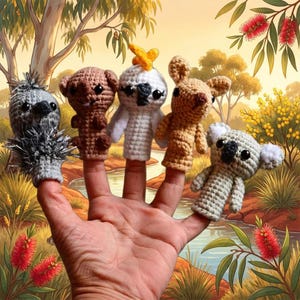 May include: A set of five crocheted finger puppets featuring Australian animals including a grey spiky echidna, a brown wombat, a white cockatoo with a yellow crest, a tan kangaroo, and a light grey koala, all with black plastic eyes.