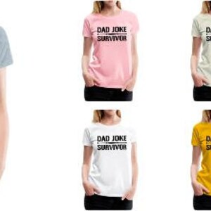 K&ouml;nnte beinhalten: Sechs T-Shirts in verschiedenen Farben mit dem Aufdruck "DAD JOKE SURVIVOR" auf der Vorderseite. Die Shirts sind in Grau, Rosa, Beige, Grau, Wei&szlig; und Gelb.