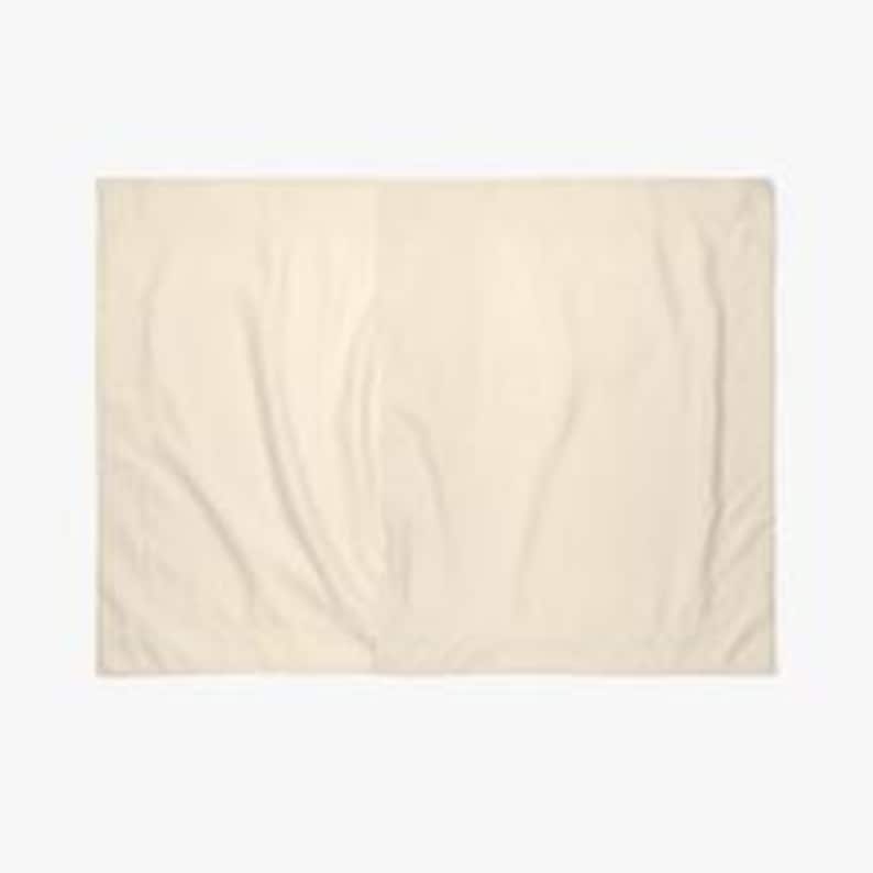 May include: A plain, off-white, rectangular throw pillow.