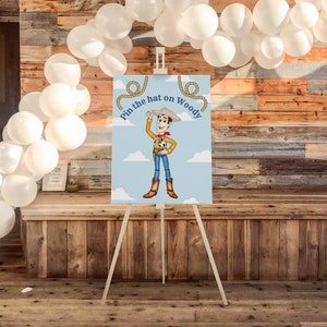 May include: A blue and white game board with a cartoon image of Woody from Toy Story. The text on the board reads "Pin the hat on Woody".
