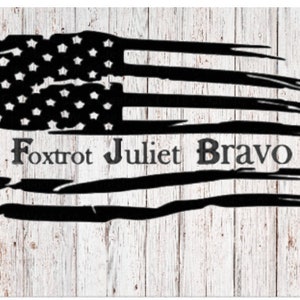 May include: A distressed black and white American flag with the words "Fox Trot Juliet Bravo" written below it.
