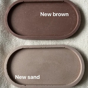 Puede incluir: Dos bandejas ovaladas de hormig&oacute;n. La bandeja superior es marr&oacute;n y dice "New brown". La bandeja inferior es de color marr&oacute;n m&aacute;s claro y dice "New sand".
