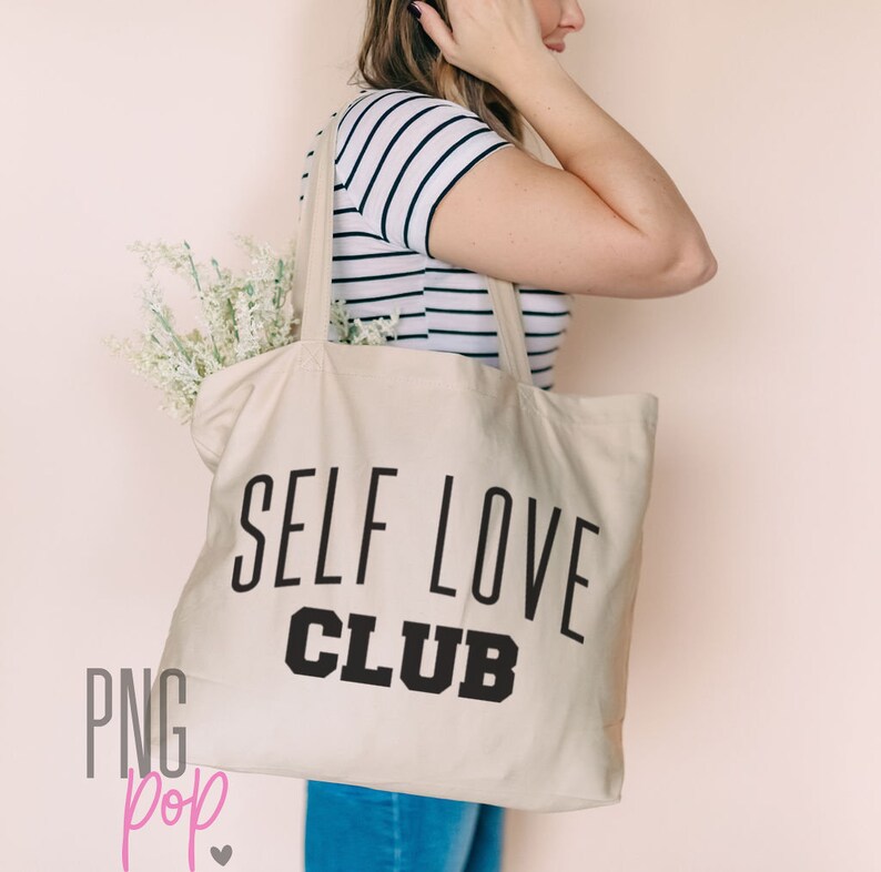 Puede incluir: Una bolsa de lona blanca con texto negro que dice "Self Love Club".