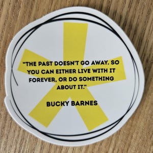 Pode incluir: Um autocolante branco com contorno preto e um design de explosão estelar amarela. O autocolante apresenta a citação "THE PAST DOESN'T GO AWAY. SO YOU CAN EITHER LIVE WITH IT FOREVER, OR DO SOMETHING ABOUT IT." de Bucky Barnes.