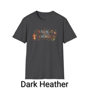 Puede incluir: Una camiseta de manga corta en color gris jaspeado oscuro con un estampado gr&aacute;fico que incluye el texto I KNEW IT I KNEW YOU. El dise&ntilde;o muestra un peque&ntilde;o oso marr&oacute;n con sombrero, un caballito de madera, un cactus y estrellas y corazones.