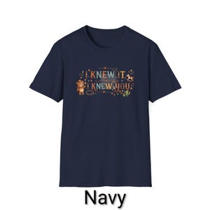 Puede incluir: Una camiseta azul marino de manga corta con un estampado gr&aacute;fico que incluye el texto I KNEW IT, I KNEW YOU. El dise&ntilde;o muestra un oso de peluche marr&oacute;n con sombrero de vaquero, un caballito balanc&iacute;n, un cactus y peque&ntilde;as estrellas y corazones.