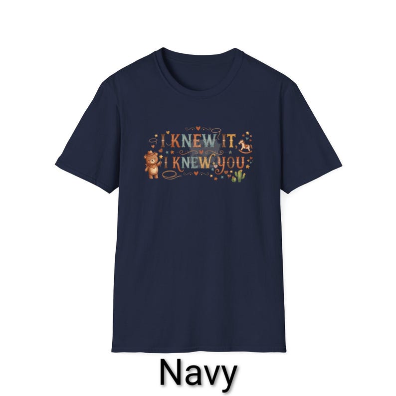 Puede incluir: Una camiseta azul marino de manga corta con un estampado gr&aacute;fico que incluye el texto I KNEW IT, I KNEW YOU. El dise&ntilde;o muestra un oso de peluche marr&oacute;n con sombrero de vaquero, un caballito balanc&iacute;n, un cactus y peque&ntilde;as estrellas y corazones.