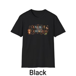 Puede incluir: Una camiseta negra de manga corta con un estampado gr&aacute;fico que incluye el texto I KNEW IT, I KNEW YOU. El dise&ntilde;o muestra un oso de peluche marr&oacute;n con sombrero de vaquero, un caballito balanc&iacute;n, un cactus verde y varios corazones y estrellas.
