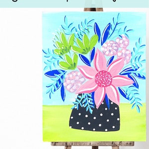 May include: A painting of a summer flower vase with pink, green, and blue flowers in a black and white polka dot vase. The painting is on a wooden easel.