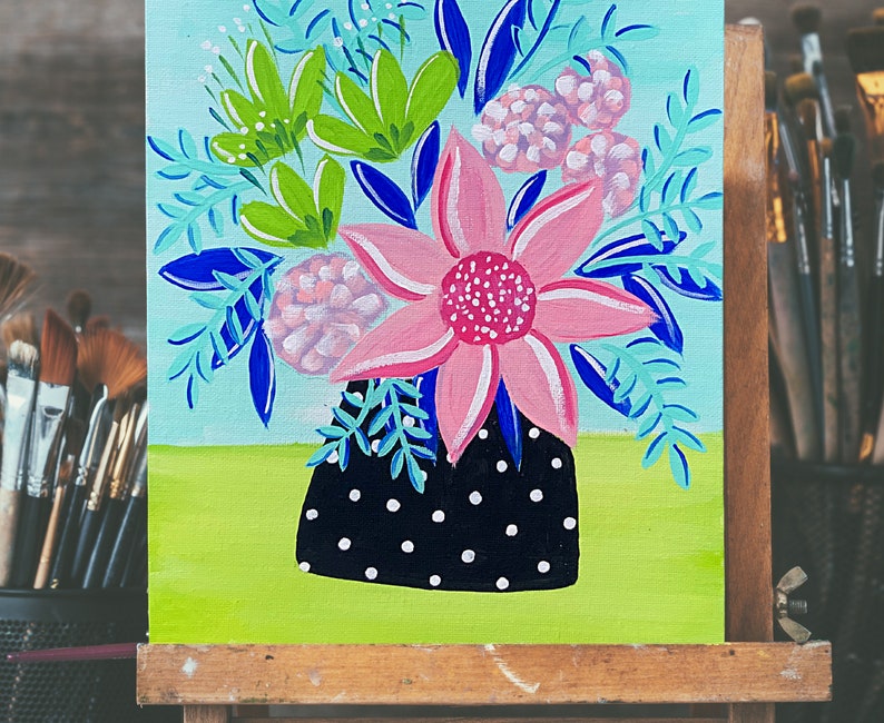 May include: A painting of a bouquet of flowers in a black and white polka dot vase. The flowers are pink, green, and blue. The background is a light blue.