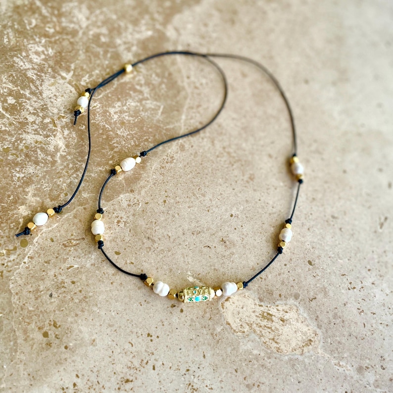 On trend adjustable cord charm necklace with love amulet talisman and freshwater cultured pearls. Choice of 3 colours.