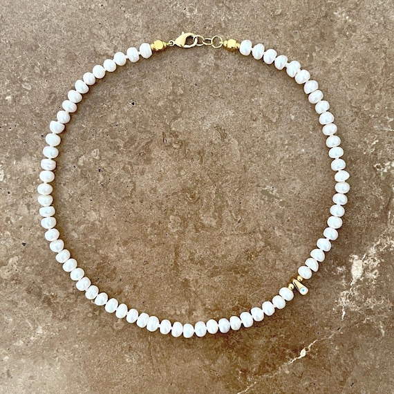 Pearl necklace with offset mini evil eye charm