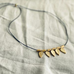 Collar de cordón ajustable con dijes de hojas de oro