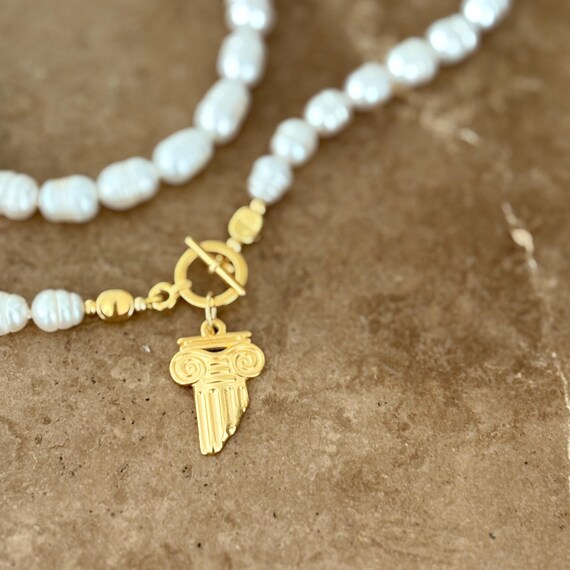 Knotted pearl necklace with gold T bar clasp and Greek column charm