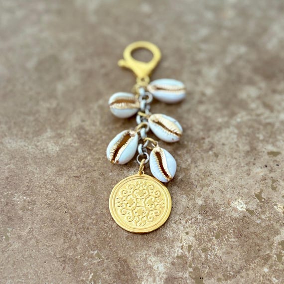 Bag charm with gold medallion and cowrie shells