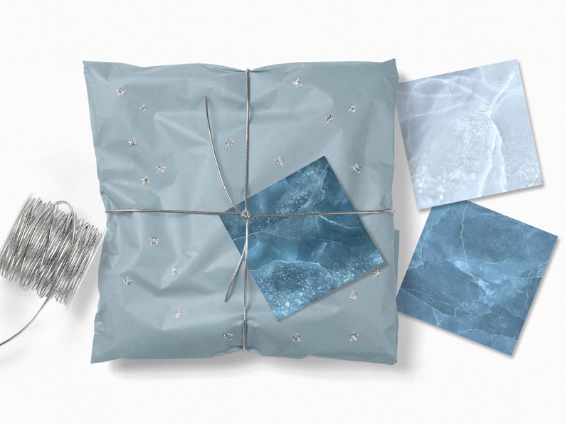 May include: A blue and white gift wrapped in blue tissue paper with silver string and silver stars. The gift is tied with a blue and white marble patterned ribbon.