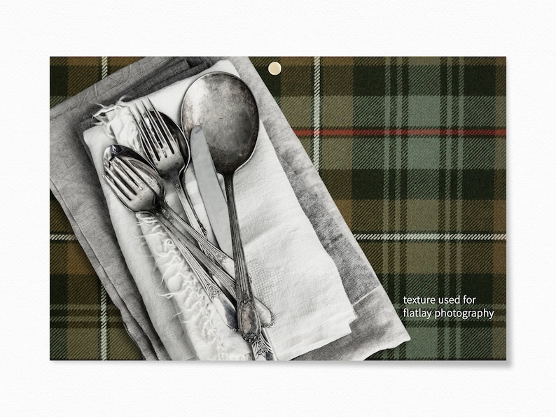 May include: Silverware, including forks and a spoon, are arranged on top of a stack of white and gray linen napkins. The napkins are on a green, brown, and white plaid fabric. The text "texture used for flatlay photography" is in the lower right corner of the image.