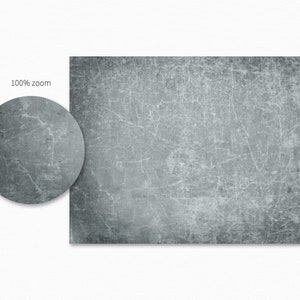 May include: A close-up of a gray, textured surface with a subtle blue tint. The surface has a distressed look with fine cracks and lines.