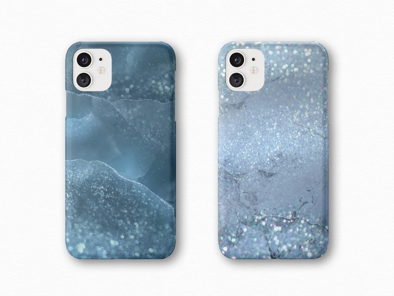 May include: Two phone cases with a blue and white marble design. The cases have a glittery finish.