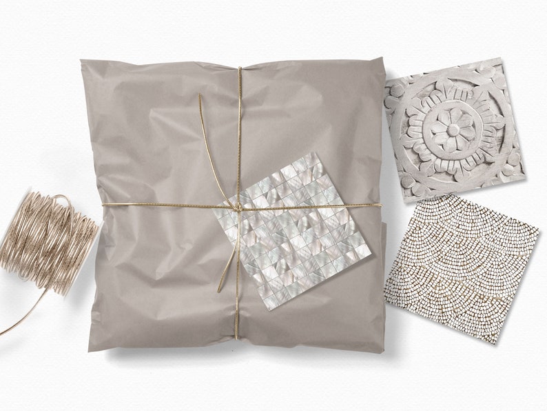 Puede incluir: Un paquete de papel marr&oacute;n atado con cuerda dorada. El paquete est&aacute; decorado con tres peque&ntilde;as muestras cuadradas de azulejos decorativos. Un azulejo es un mosaico blanco y gris, otro es un patr&oacute;n de cuentas blancas y doradas, y el &uacute;ltimo es un dise&ntilde;o floral blanco tallado.