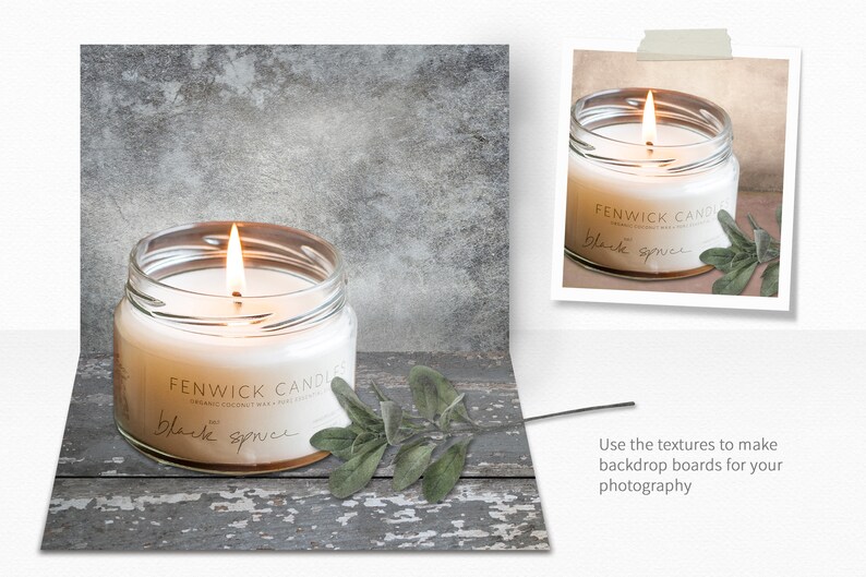 Op de afbeelding: Een brandende kaars in een glazen pot met een label waarop "FENWICK CANDLES" en "black spruce" staat. De kaars staat op een rustiek houten oppervlak met een takje groene bladeren.