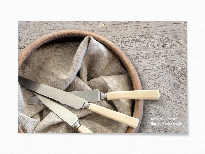 Puede incluir: Tres cuchillos de plata con mangos de marfil est&aacute;n dispuestos en un cuenco de madera forrado con un pa&ntilde;o de lino beige. El cuenco est&aacute; sobre una superficie de madera gris claro. "textura utilizada para la fotograf&iacute;a de plano" est&aacute; escrito en blanco en la esquina inferior derecha de la imagen.