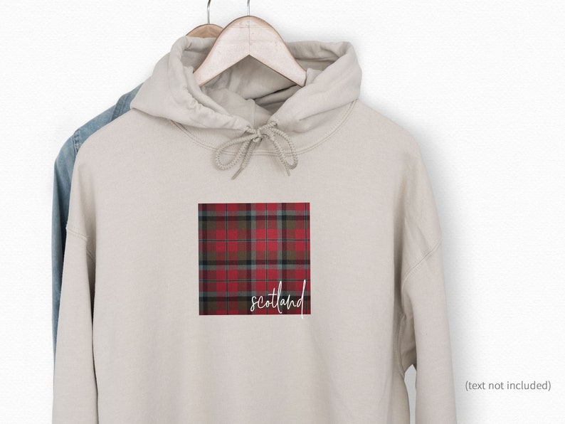 May include: A beige hoodie with a red and black plaid pattern and the word "Scotland" printed on the front.