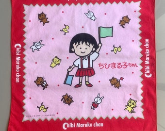 May include: A pink and red fabric handkerchief with a cartoon girl character holding a flag. The text "Chibi Maruko chan" is printed on the handkerchief in both English and Japanese.