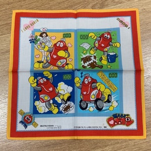 Puede incluir: Un pañuelo de algodón rojo y blanco con un personaje de robot de dibujos animados. El robot es rojo con una cara amarilla y un corazón rojo en el pecho. El pañuelo tiene un borde amarillo y un borde rojo. El texto "I Love Robin" está impreso en el pañuelo. El texto "MATSUYAMA COTTON 100%" está impreso en el pañuelo.