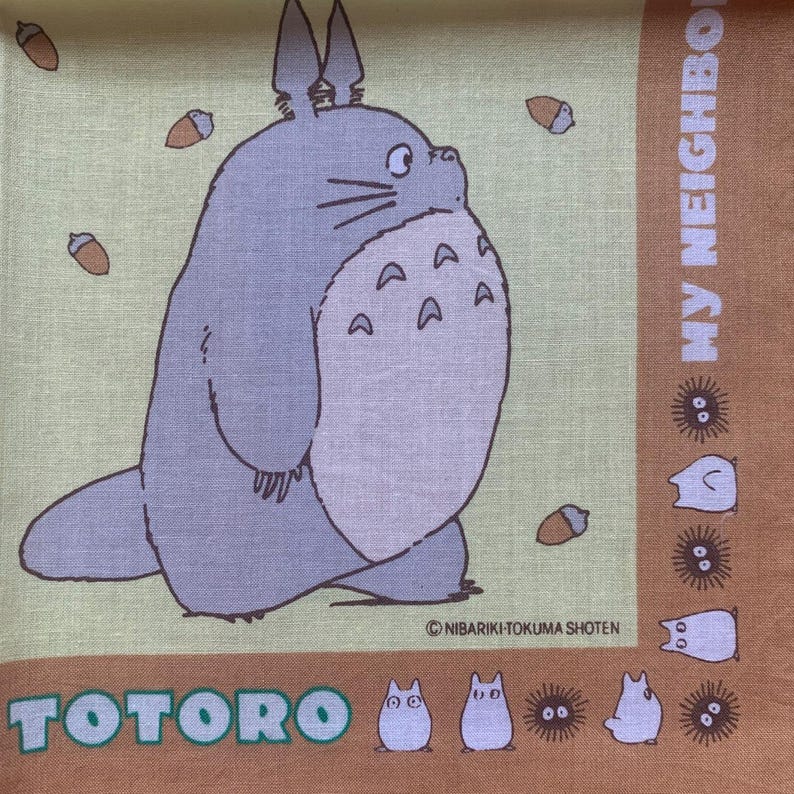 K&ouml;nnte beinhalten: Ein quadratischer, hellgr&uuml;ner und brauner Stoff mit der Figur Totoro aus dem Zeichentrickfilm Mein Nachbar Totoro. Das Bild enth&auml;lt den Text "TOTORO" und "MY NEIGHBOR". Das Design umfasst Eicheln und andere Charaktere.