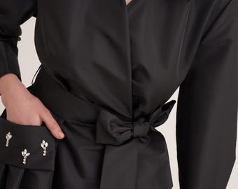 Caftán cruzado de tafetán satinado negro con detalle de bolsillo adornado con cristales hechos a mano.