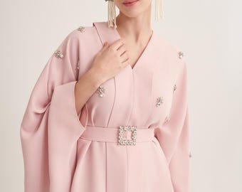 Kaftán rosa empolvado con escote en V, adornos de cristal hechos a mano y hebilla de cinturón con joyas.