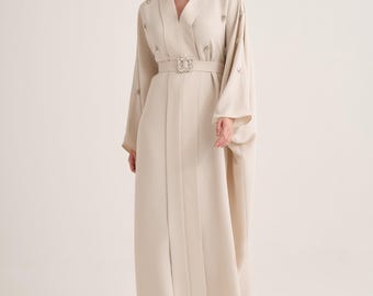 Kaftán beige con escote en V, adornos de cristal hechos a mano y hebilla de cinturón con joyas.