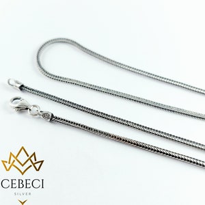 May include: A silver chain necklace with a 925 stamp. The chain is a snake chain style.