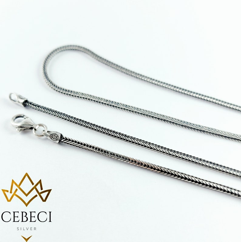 May include: A silver chain necklace with a 925 stamp. The chain is a snake chain style.