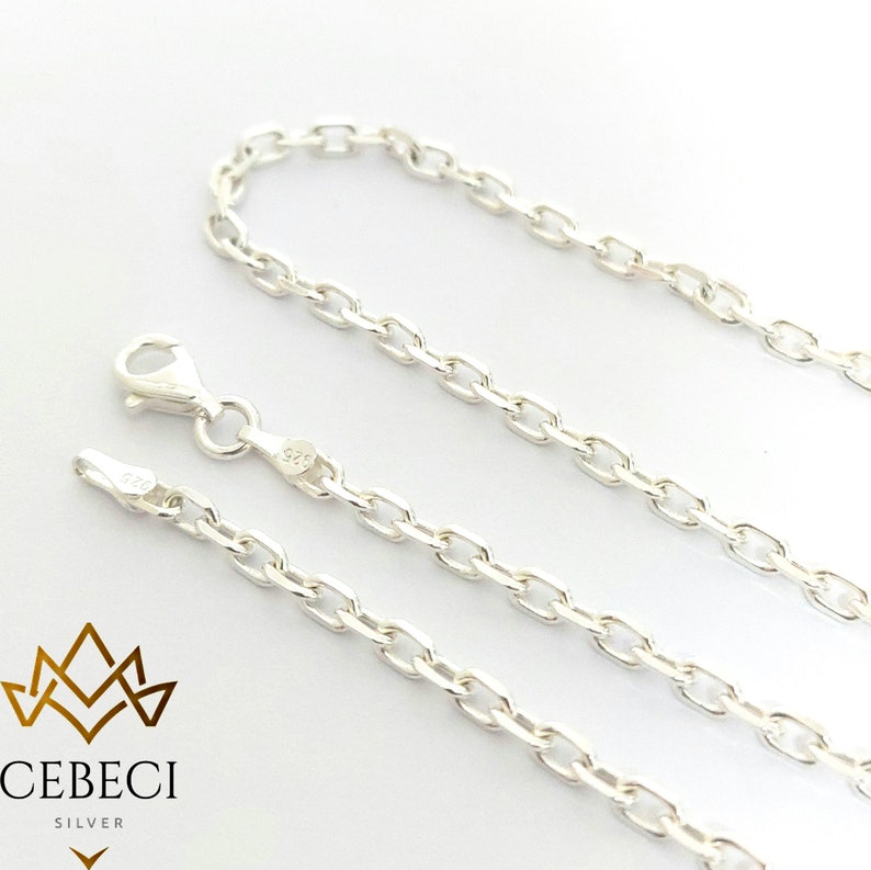 May include: Three silver chains with a lobster clasp. The chains are made of a delicate, oval-shaped link.