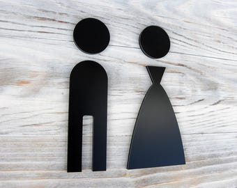 Figure di disabili per uomo e donna nei bagni. Simboli adesivi neri opachi per porte dei bagni. Cartelli moderni per WC. Disabili per donne e uomini.