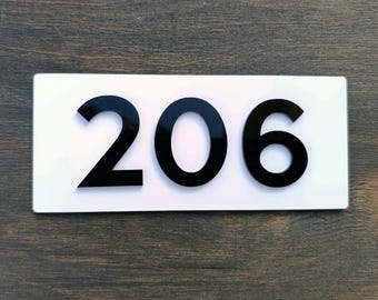 Targhe per porte di appartamenti. Targhe moderne per appartamenti. Numeri civici bianchi. Numeri adesivi personalizzati. Targhe personalizzate.