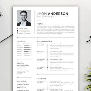 Peut inclure: Modèle de CV en noir et blanc avec une photo d'un homme. Le CV comprend des coordonnées, des compétences, une expérience professionnelle, des récompenses, des références et une formation. Le texte du CV comprend le nom Jhon Anderson, Web & Graphic Designer, et le titre Graphic Designer.
