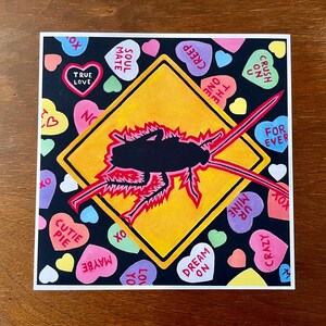 May include: A yellow diamond-shaped road sign with a black silhouette of a cockroach inside. The sign is surrounded by colorful candy hearts with various messages like "Soul Mate", "True Love", "Crush On U", "Dream On", and "Forever".
