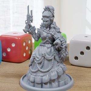 May include: A grey 3D printed miniature of a woman wearing a long dress and holding a gun. She has a stern expression on her face and is wearing a crown. The miniature is standing on a round base.