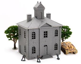 Puede incluir: Un modelo gris de un edificio con un tejado detallado, ventanas y una pequeña torre. Soldados en miniatura y un tanque de camuflaje están colocados cerca del edificio, con dos árboles verdes a cada lado. Una escena de diorama.